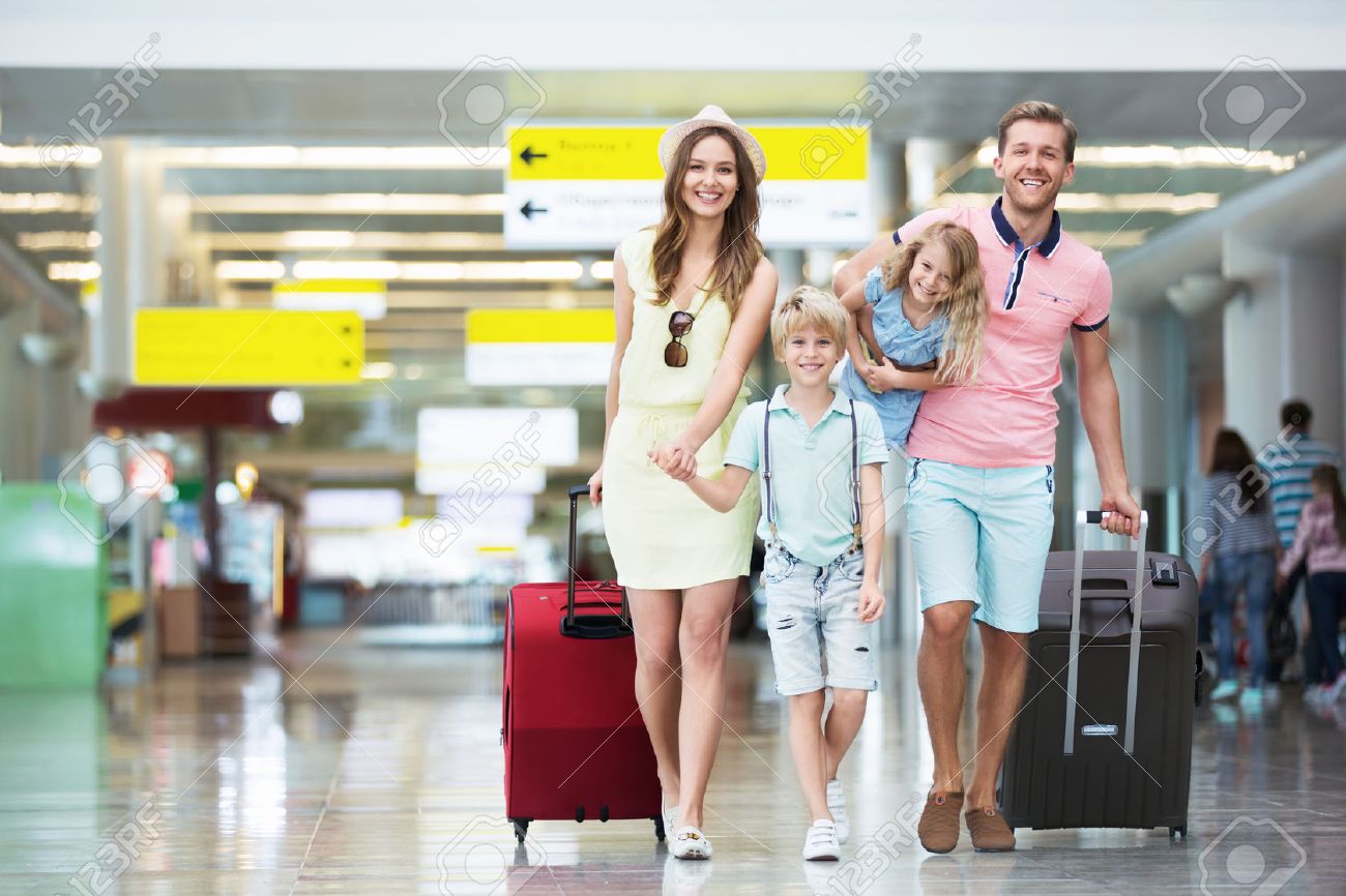Happy family with suitcases in the airport - 45818113 Happy family with suitcases in the airport - 45818113