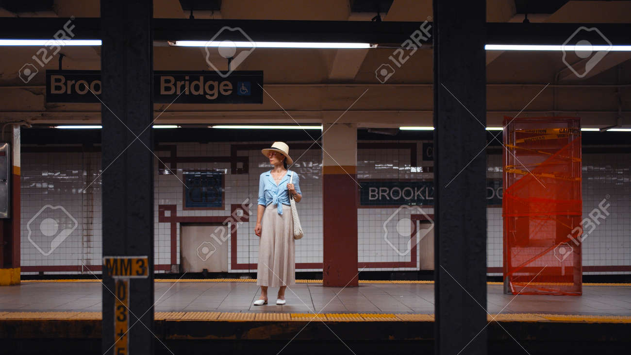 Young tourist waiting for a train at the station in the subway, New York City - 152488014 Young tourist waiting for a train at the station in the subway, New York City - 152488014