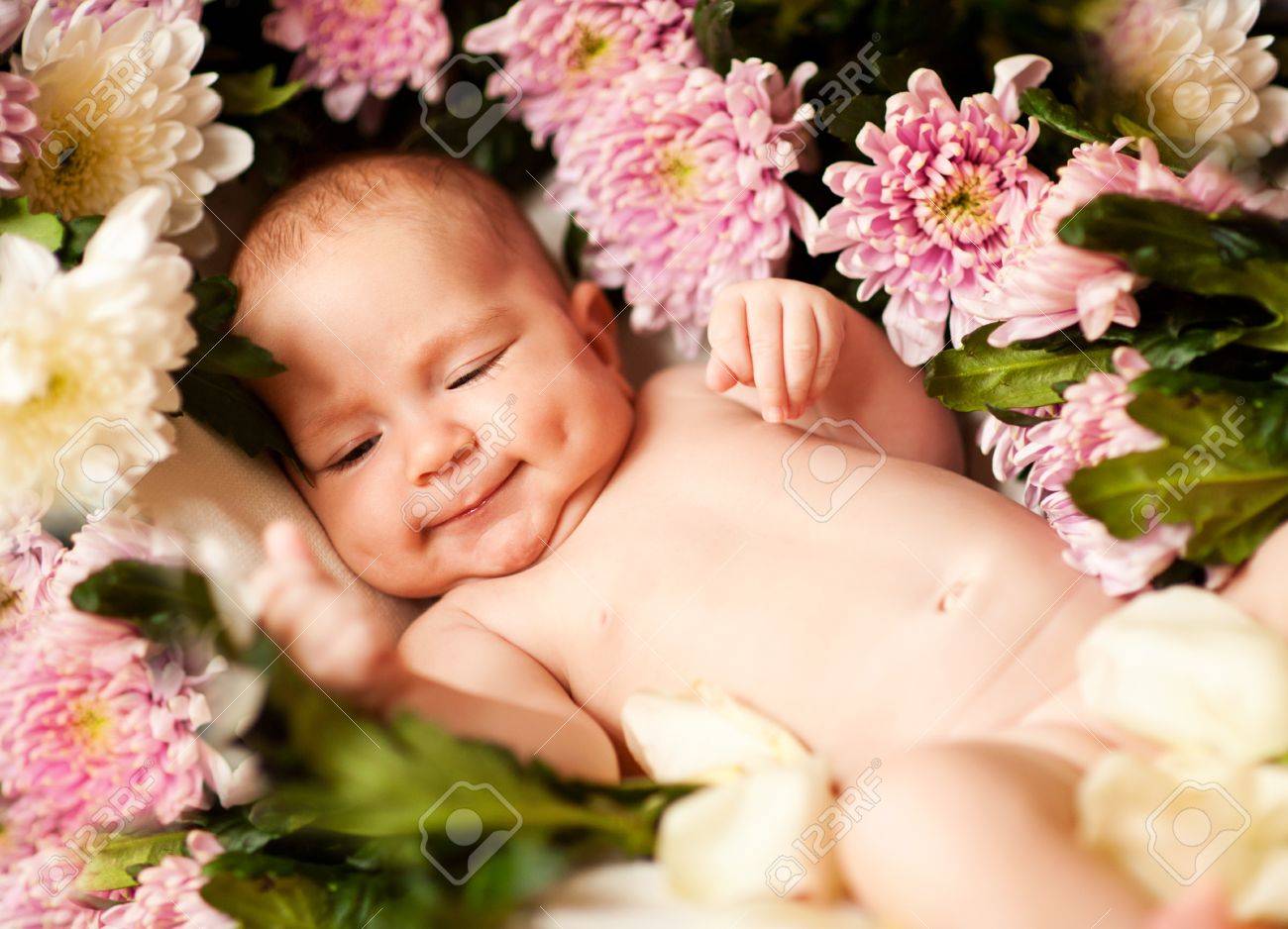 花で魅力的な笑顔赤ちゃん の写真素材 画像素材 Image