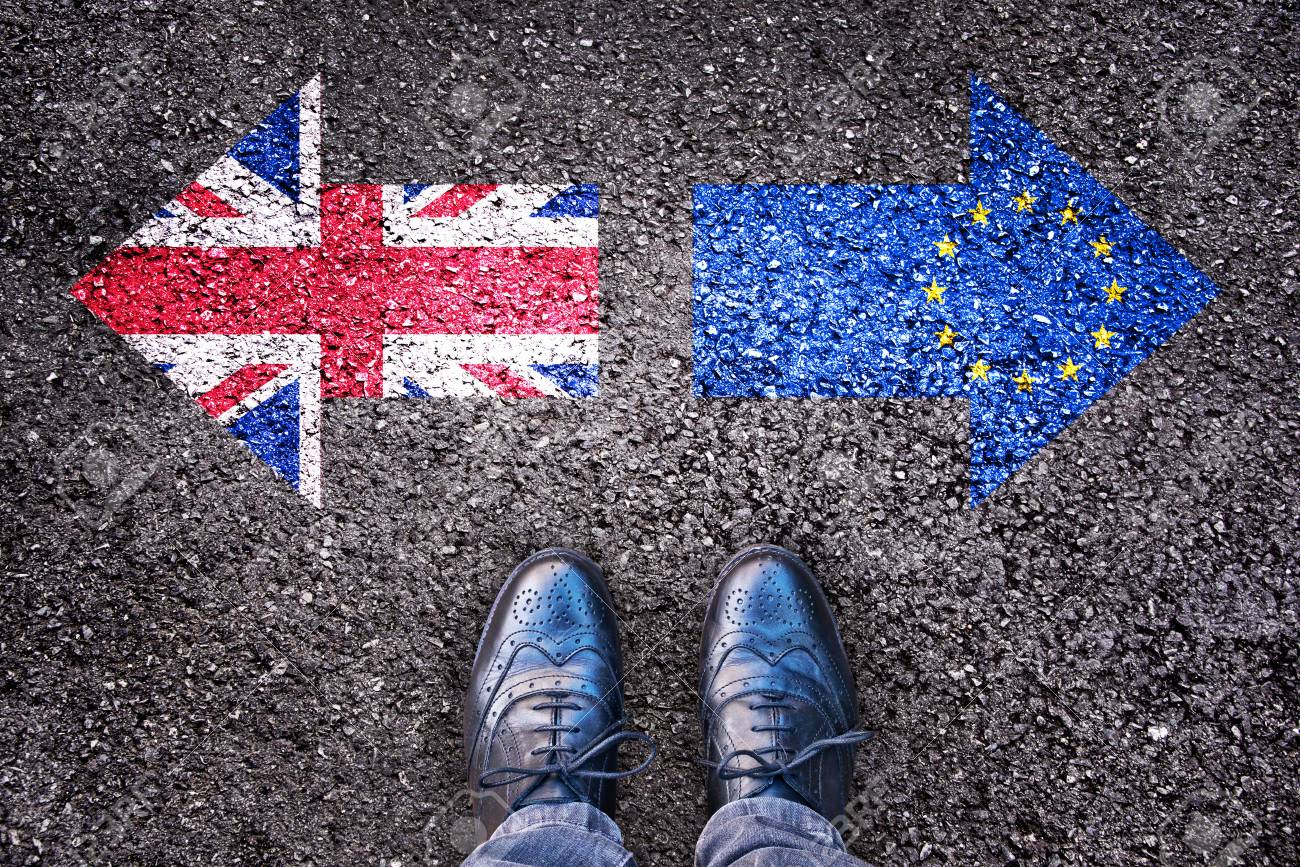 Brexit, flags of the United Kingdom and the European Union on asphalt road with legs - 61288385 Brexit, flags of the United Kingdom and the European Union on asphalt road with legs - 61288385