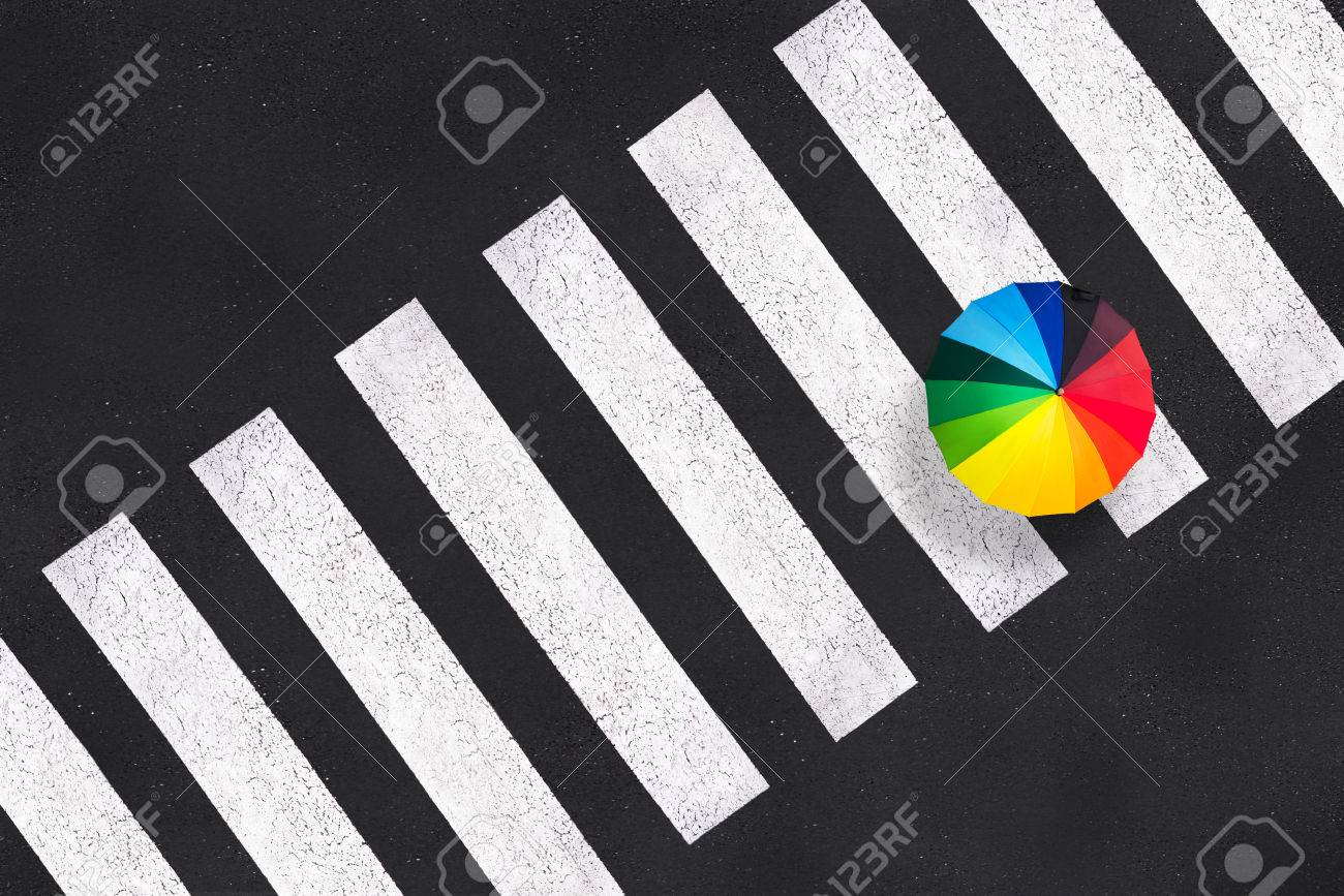 Top view of a rainbow umbrella on a pedestrian crosswalk - 63621034 Top view of a rainbow umbrella on a pedestrian crosswalk - 63621034