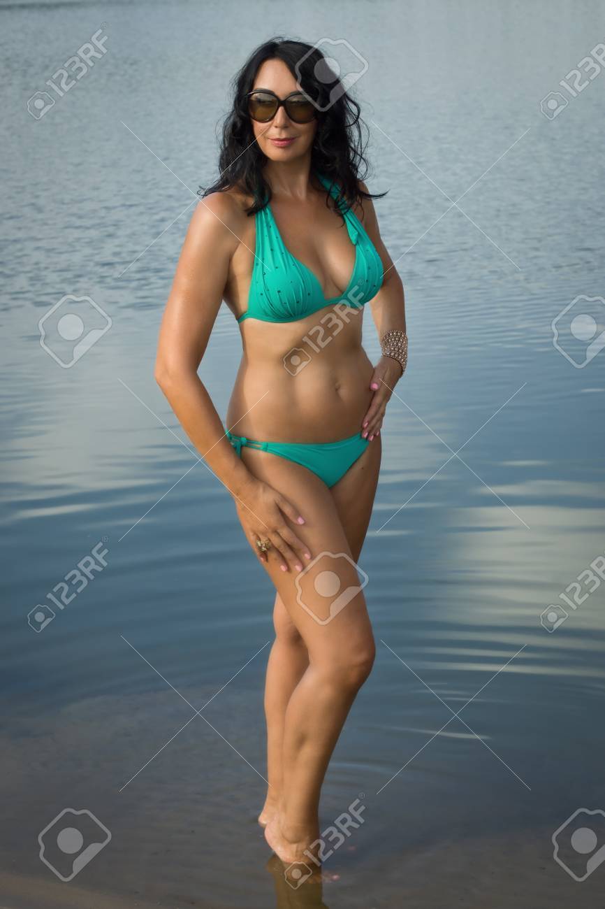 Beautiful Adult Woman In Bikini Relaxing On The Beach By The Lake Stock  Photo, Picture and Royalty Free Image. Image 65496571.