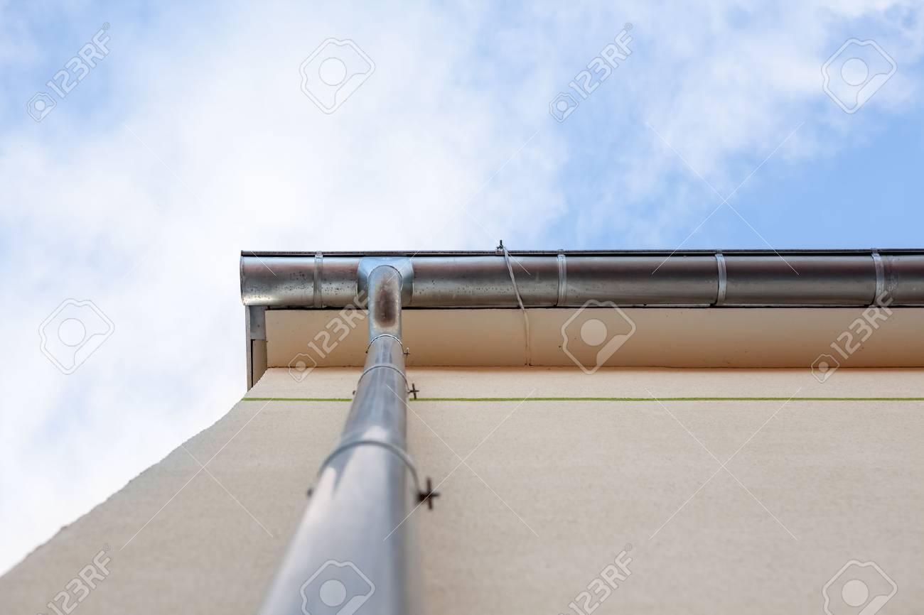 an rain drain pipe from the roof whit blue sky and clouds - 85093472 an rain drain pipe from the roof whit blue sky and clouds - 85093472