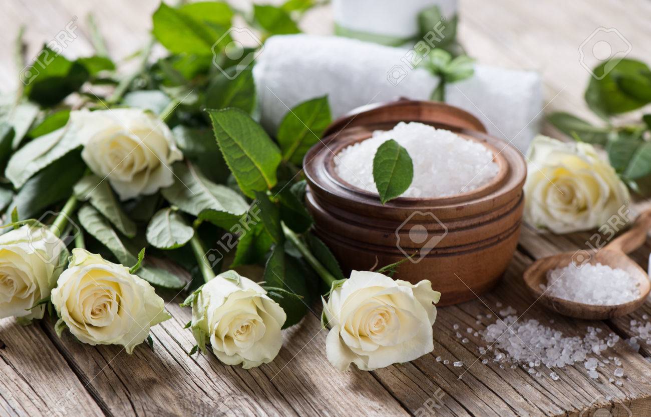 archivio fotografico composizione spa su tavola di legno con rose bianche e bagno di sale