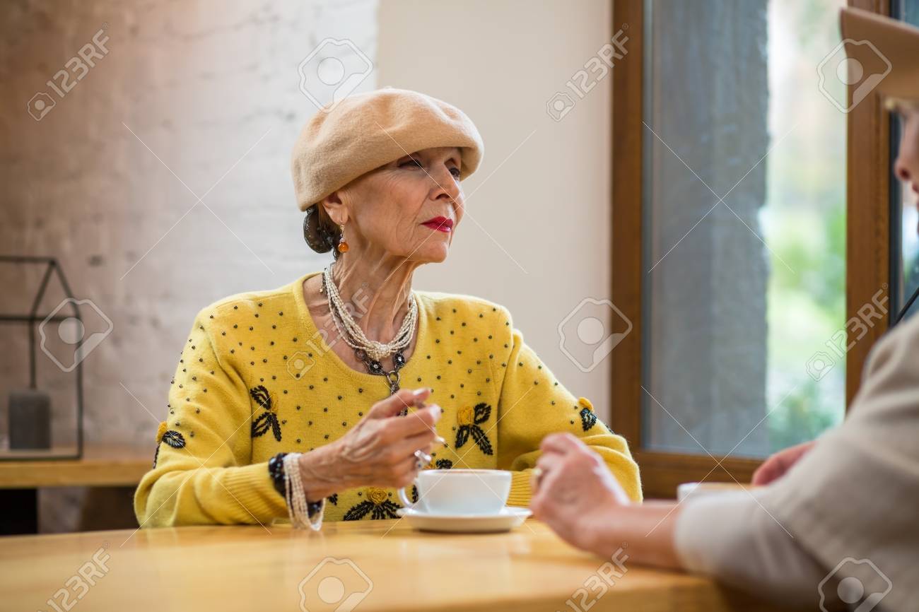 年配の女性とコーヒー カップ 怪訝な顔の年配の女性 もっと教えてください の写真素材 画像素材 Image
