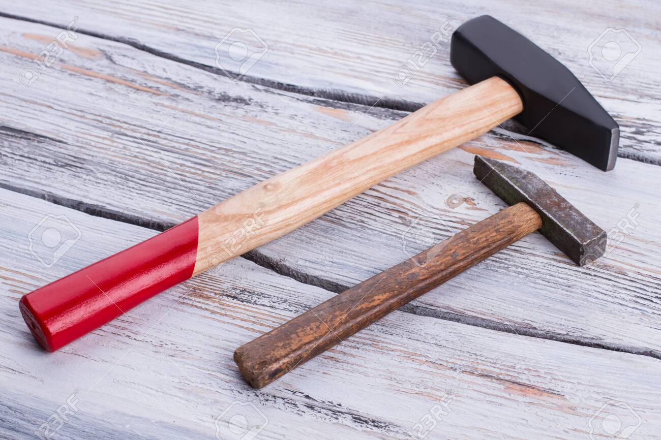 Old and new hammers on wooden background. Hammers with wooden handles on wood surface. - 124519284 Old and new hammers on wooden background. Hammers with wooden handles on wood surface. - 124519284