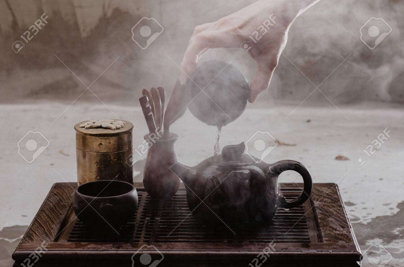 Cropped shot of woman pouring tea in traditional chinese teaware - 144389529 Cropped shot of woman pouring tea in traditional chinese teaware - 144389529