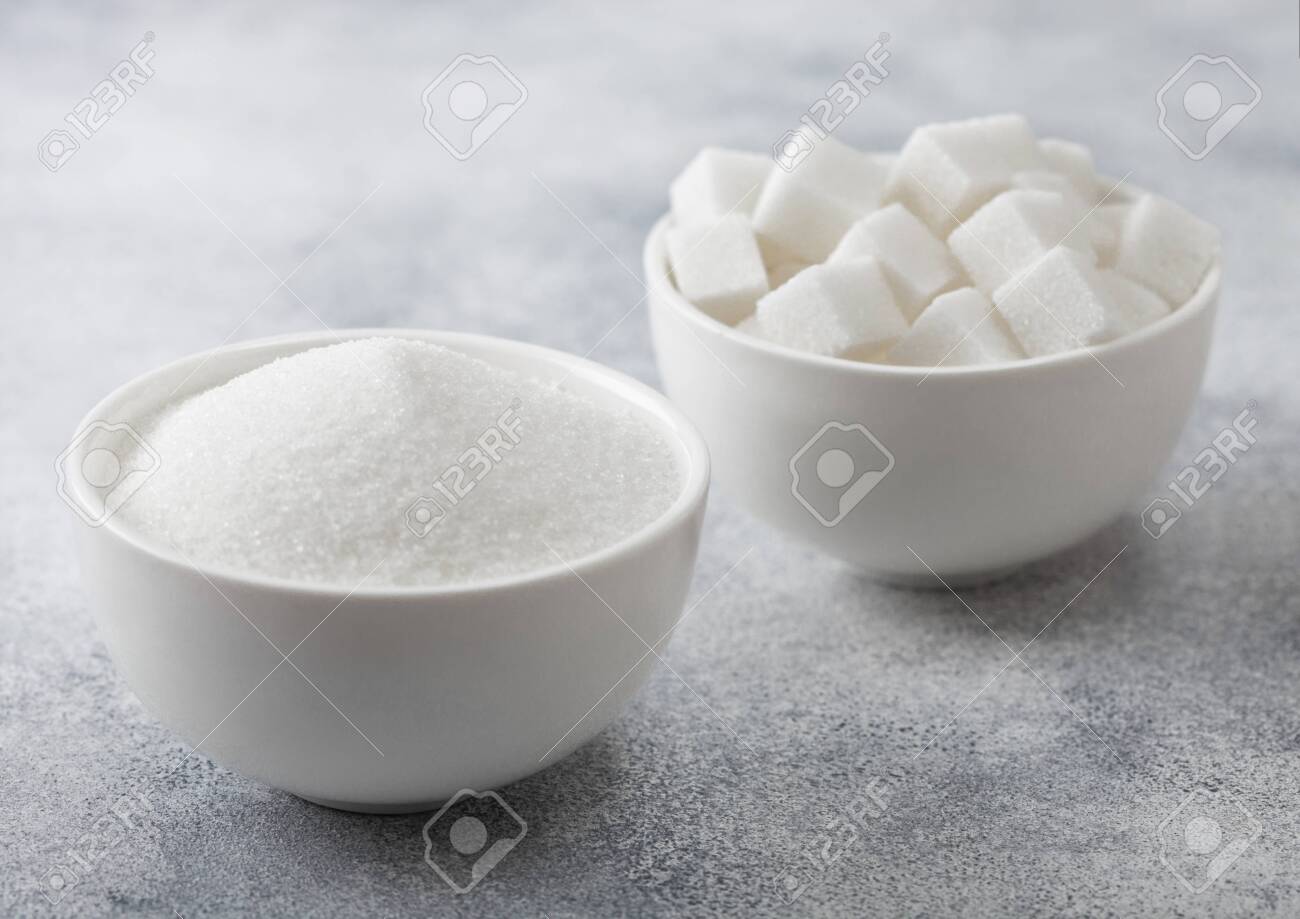 White bowl plates of natural white sugar cubes and refined sugar on light background. Top view - 138345437 White bowl plates of natural white sugar cubes and refined sugar on light background. Top view - 138345437