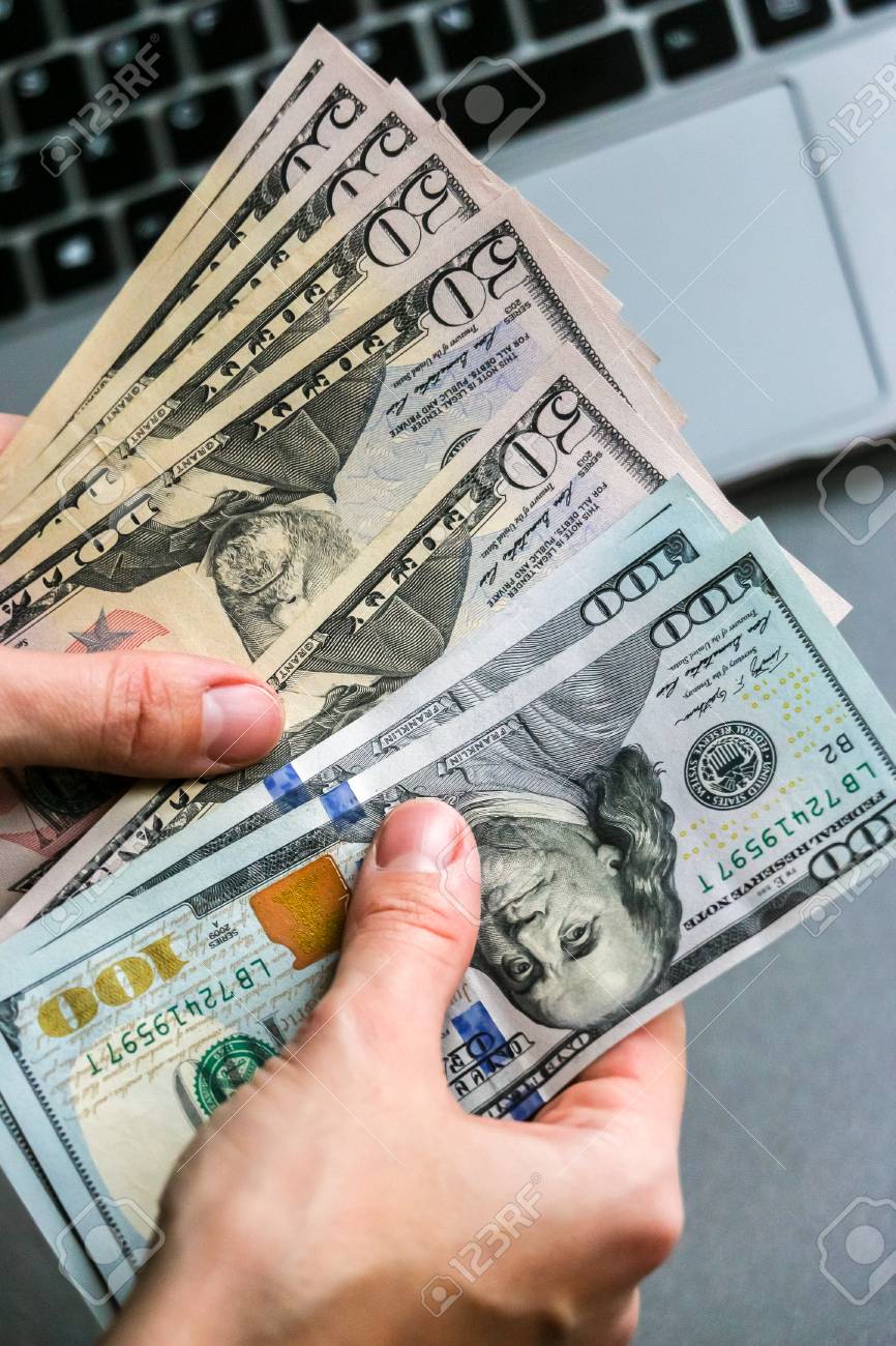 백그라운드에서 150달러 지폐 노트북 키보드를 들고 있는 손 로열티 무료 사진, 그림, 이미지 그리고 스톡포토그래피. Image  112810438