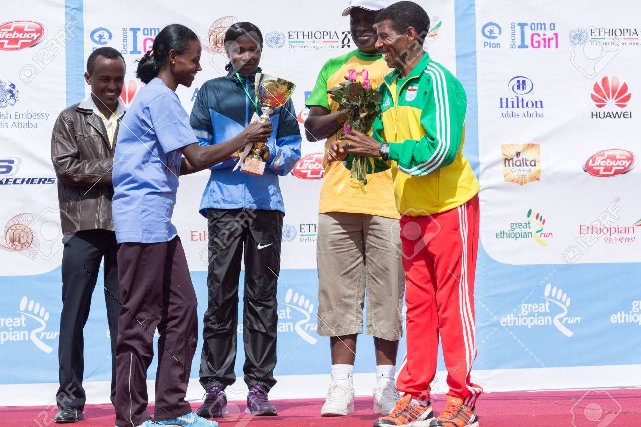 Netsanet Gudeta 13 版偉大なエチオピア実行女性のレースの勝者世界的に有名なスポーツ選手 13 版偉大なエチオピアで実行する 13 年 11 月 24 日にアディスアベバ エチオピアのハイレ Gebresellase から花とトロフィーを受け取る の写真素材 画像素材 Image