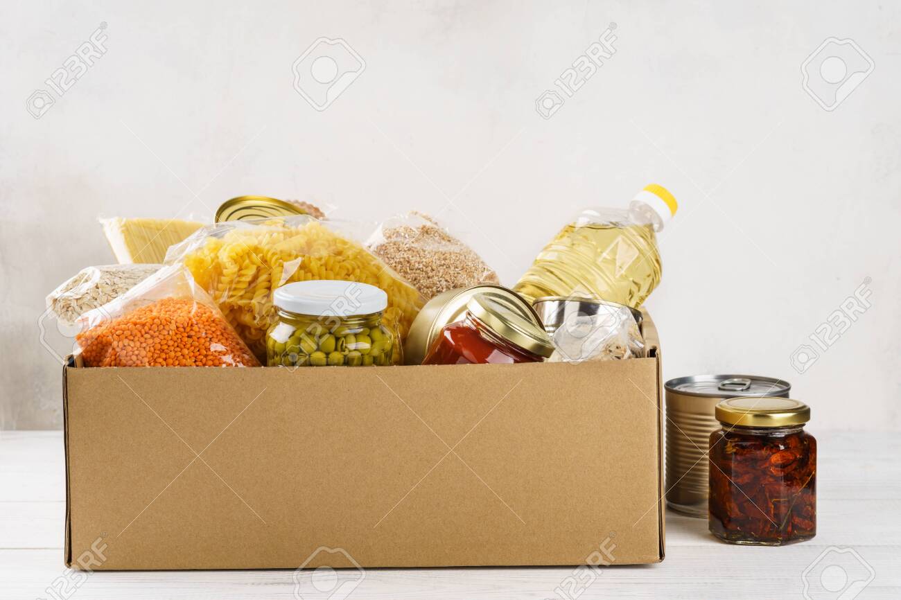 Various canned food, pasta and cereals in a cardboard box. Food donations or food delivery concept. - 126798569 Various canned food, pasta and cereals in a cardboard box. Food donations or food delivery concept. - 126798569