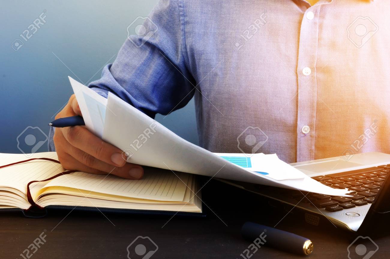 Auditor checking financial report. Paperwork in the office and audit. - 106627547 Auditor checking financial report. Paperwork in the office and audit. - 106627547