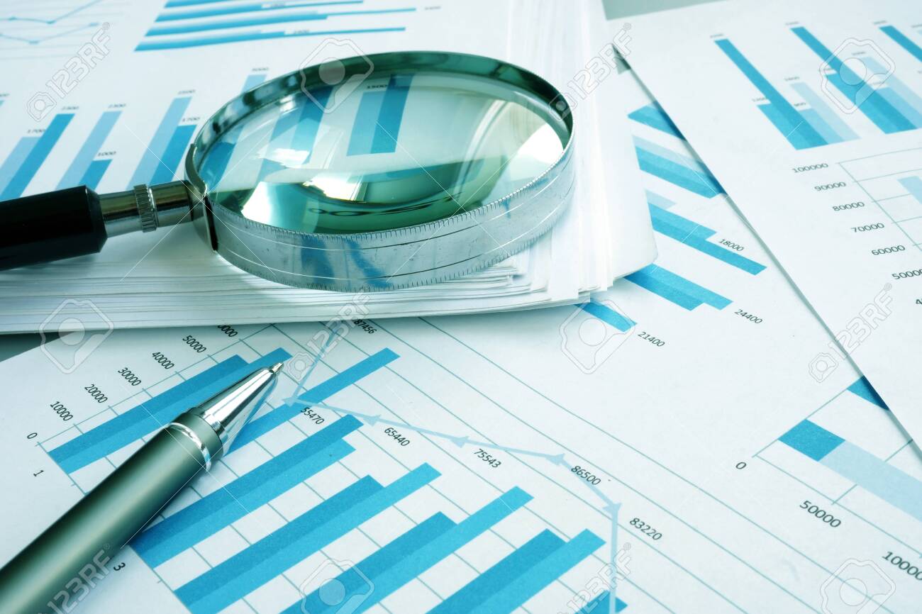 Assessment and audit. Business papers with financial charts and Magnifying glass. - 124399625 Assessment and audit. Business papers with financial charts and Magnifying glass. - 124399625