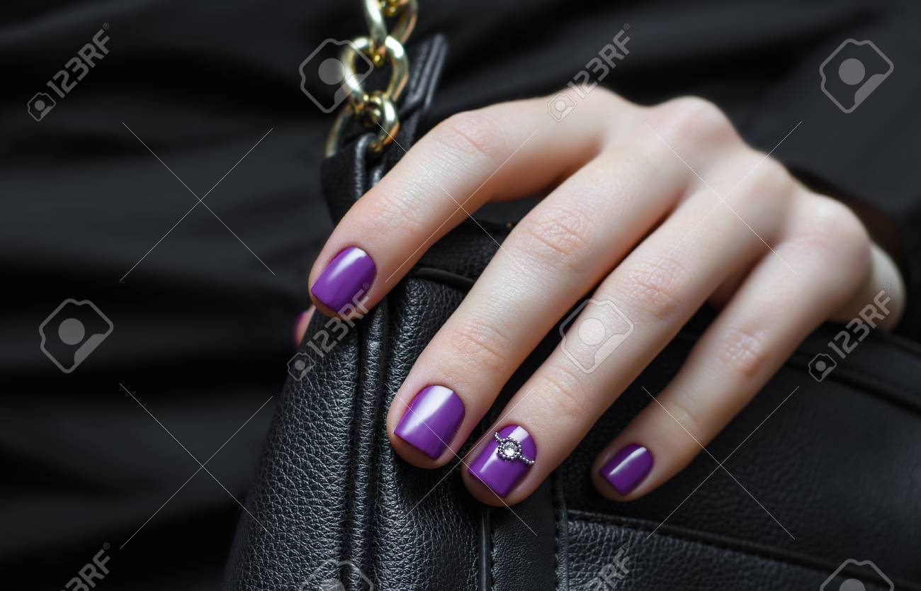 紫色の爪デザインと黒のハンドバッグの女性の手 の写真素材 画像素材 Image
