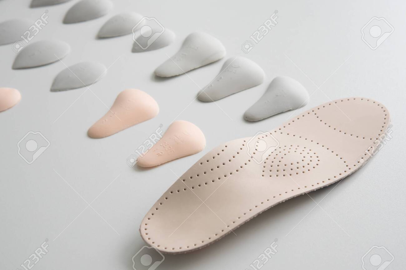 Orthopedic insole on a white background. Treatment and prevention of flat feet and foot diseases. Foot care, foot comfort. Wear comfortable shoes. - 144810352 Orthopedic insole on a white background. Treatment and prevention of flat feet and foot diseases. Foot care, foot comfort. Wear comfortable shoes. - 144810352