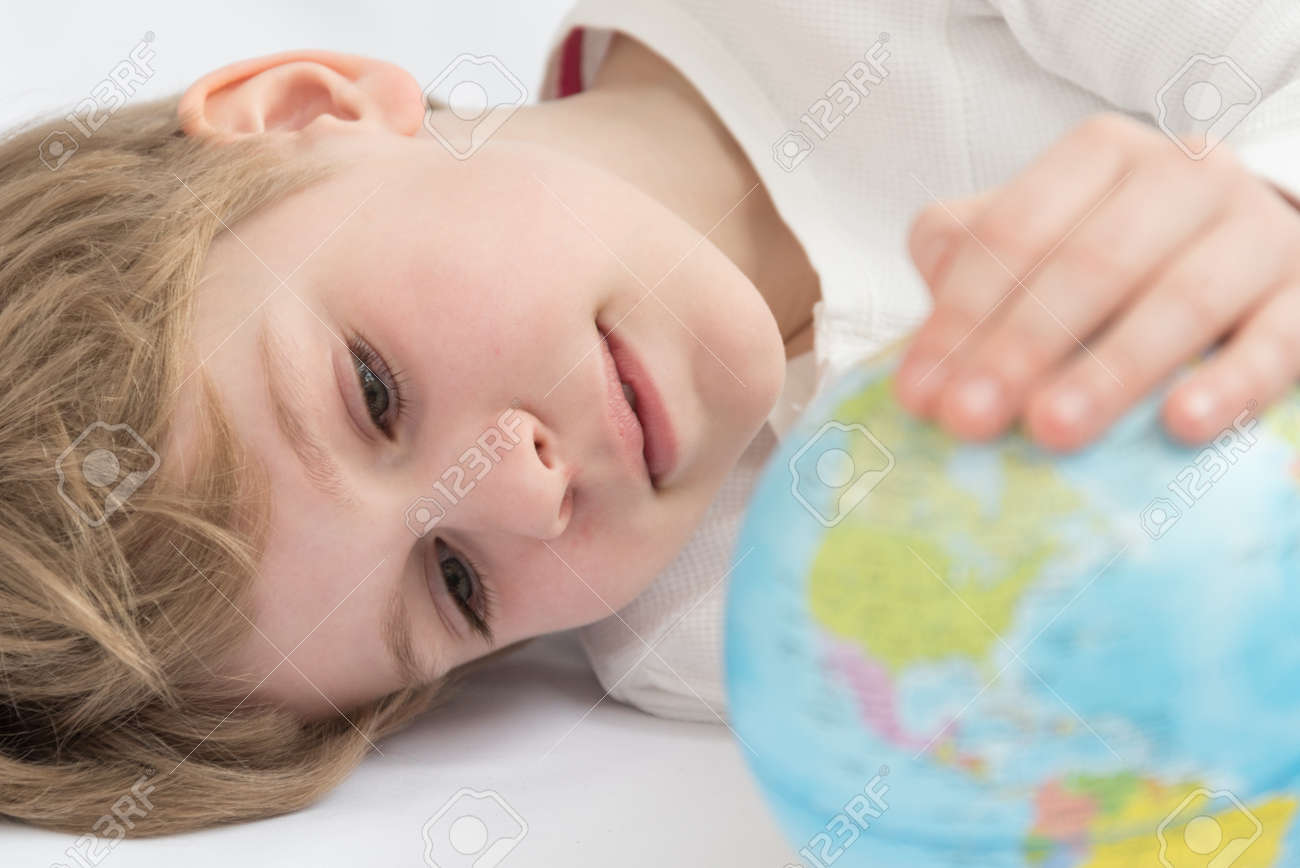 The child dreamily examines the globe. Travel yearning concept. Closed borders and quarantine. A European-looking child dreams of travel - 167431552 The child dreamily examines the globe. Travel yearning concept. Closed borders and quarantine. A European-looking child dreams of travel - 167431552