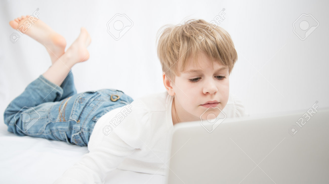 The blond child looks attentively at the computer or laptop screen. Close-up portrait - 168593051 The blond child looks attentively at the computer or laptop screen. Close-up portrait - 168593051