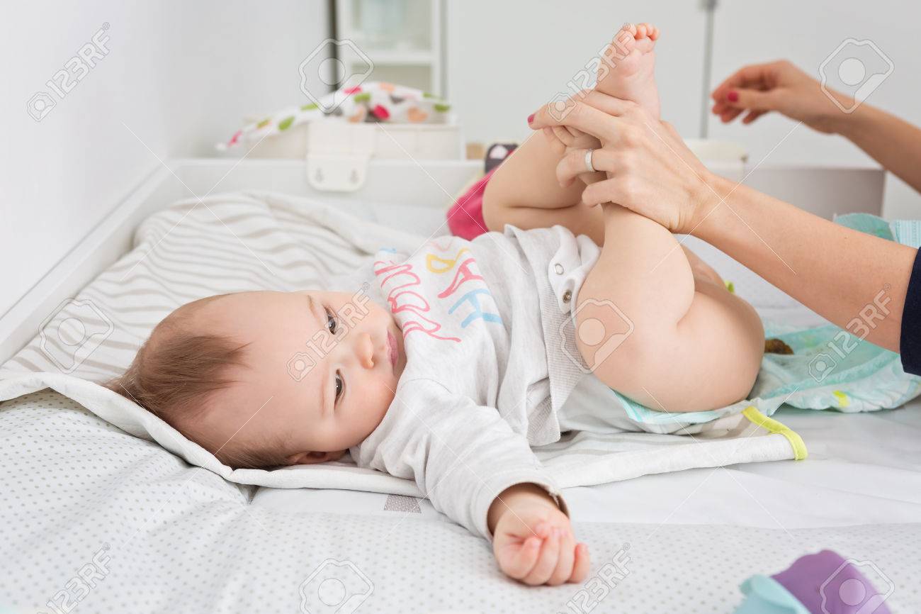 Mere Changer Les Couches D Un Bebe Fille Agee De Neuf Mois Fille Enfant Pose Sur Le Bureau Dans La Creche Les Meres Mains Visibles Banque D Images Et Photos Libres De Droits Image