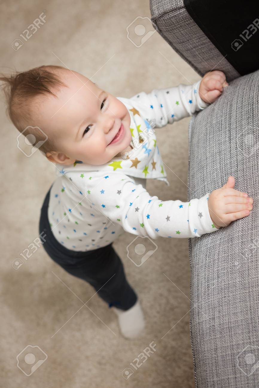 Une Petite Fille Agee De Neuf Mois Se Tient Debout Pour Tenter De Grimper Sur Le Canape Bebe Vient D Apprendre A Se Tenir Debout Banque D Images Et Photos Libres De Droits Image