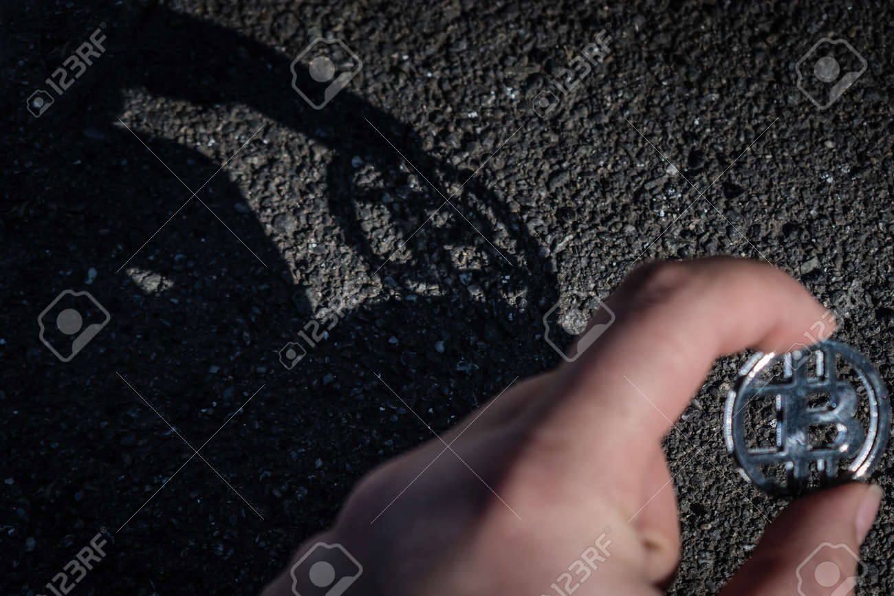 손에 들고 있는 플라스틱 비트코인과 바닥에 있는 그림자 로열티 무료 사진, 그림, 이미지 그리고 스톡포토그래피. Image  116188563