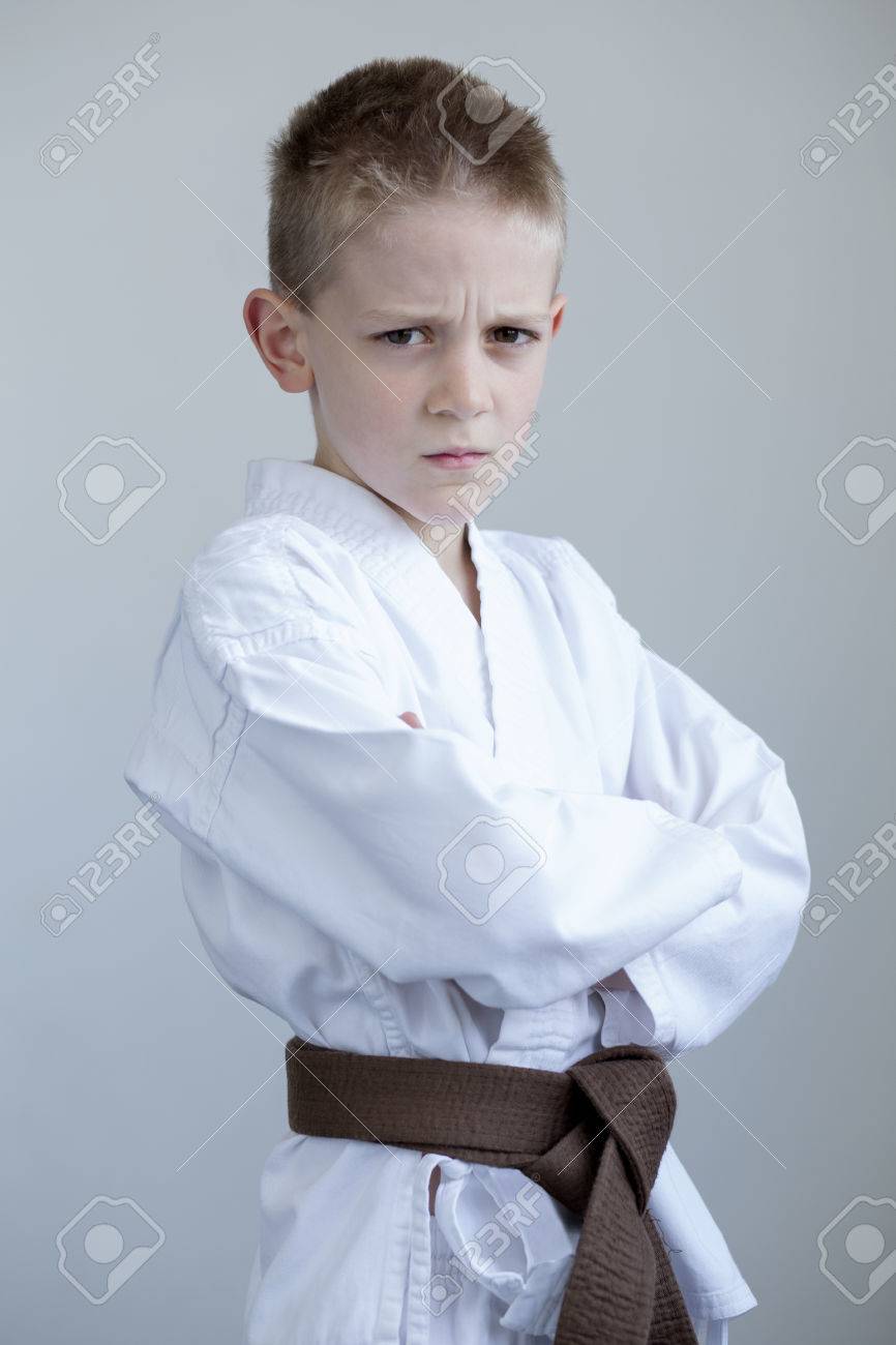 厳しい表情で彼の顔と腕を組んでポーズをとって空手服の少年は の写真素材 画像素材 Image