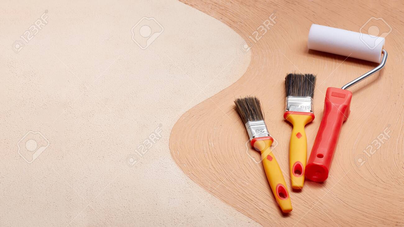 Yellow paint brushes and red roller lying on textural double background consisting of two beige shades. Top view with copy space, Concept of construction or design office - 121914760 Yellow paint brushes and red roller lying on textural double background consisting of two beige shades. Top view with copy space, Concept of construction or design office - 121914760