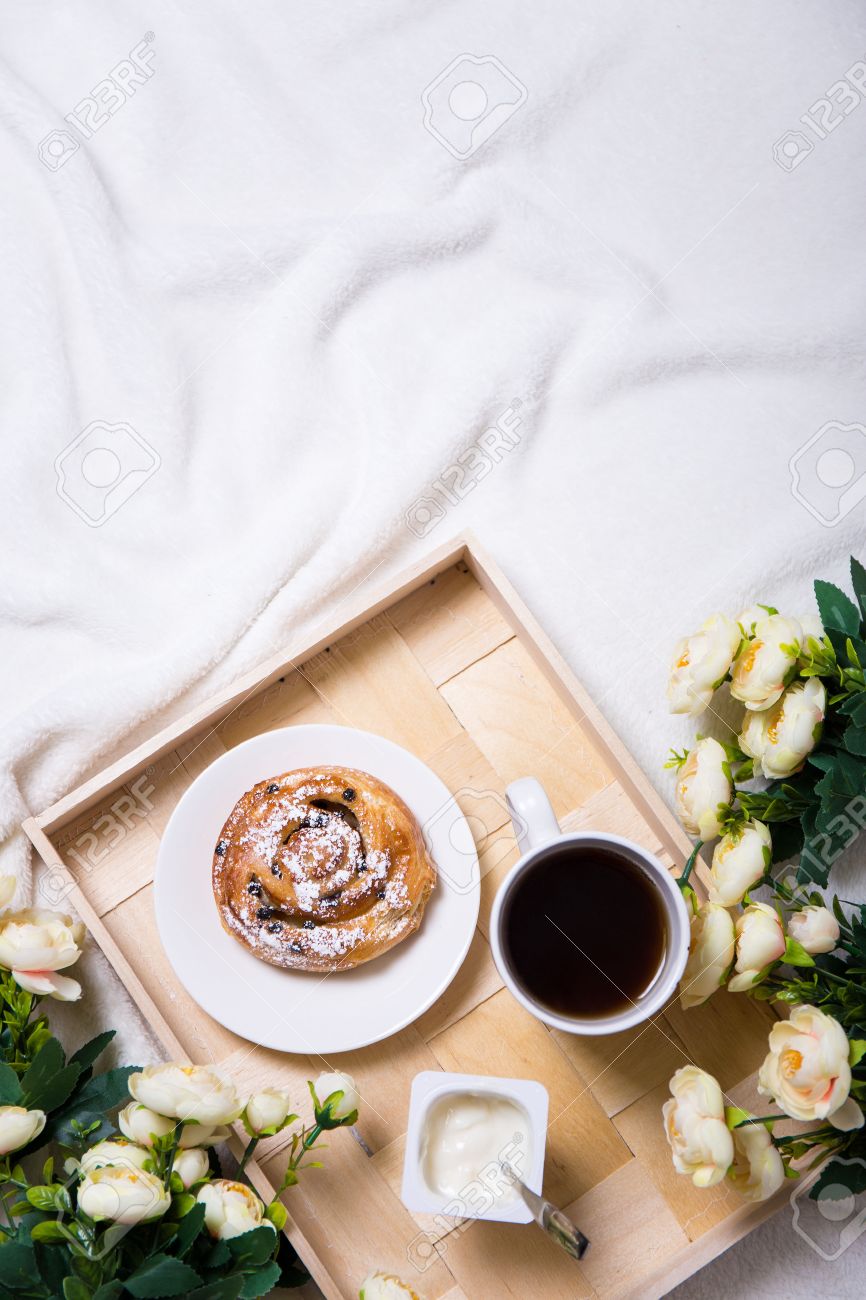 good morning - breakfast with sweet bun and tea on wooden tray and flowers in bed - 54018780 good morning - breakfast with sweet bun and tea on wooden tray and flowers in bed - 54018780