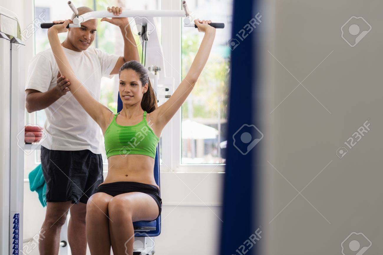 People And Sports Man At Work As Personal Trainer Helping Young Female Athlete Exercising People And Sports Man At Work As Personal Trainer Helping Young Female Athlete Exercising