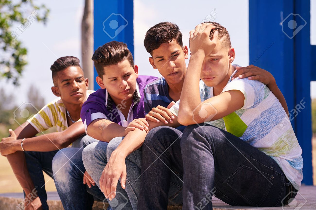 Youth culture, young people, group of male friends, multi-ethnic teens outdoor, teenagers together in park. Boys comforting sad friend, kids helping depressed boy. Adolescence bond, relationship - 58642930 Youth culture, young people, group of male friends, multi-ethnic teens outdoor, teenagers together in park. Boys comforting sad friend, kids helping depressed boy. Adolescence bond, relationship - 58642930