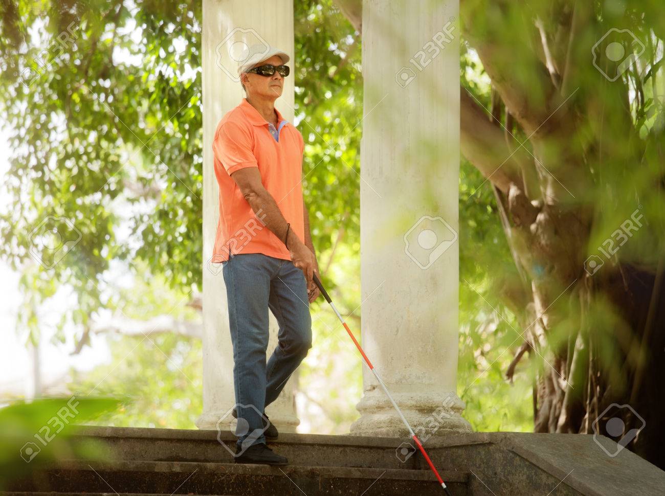 Hispanic blind man, latino people with disability, handicapped person and everyday life. Visually impaired man with walking stick, descending steps in city park - 80274976 Hispanic blind man, latino people with disability, handicapped person and everyday life. Visually impaired man with walking stick, descending steps in city park - 80274976