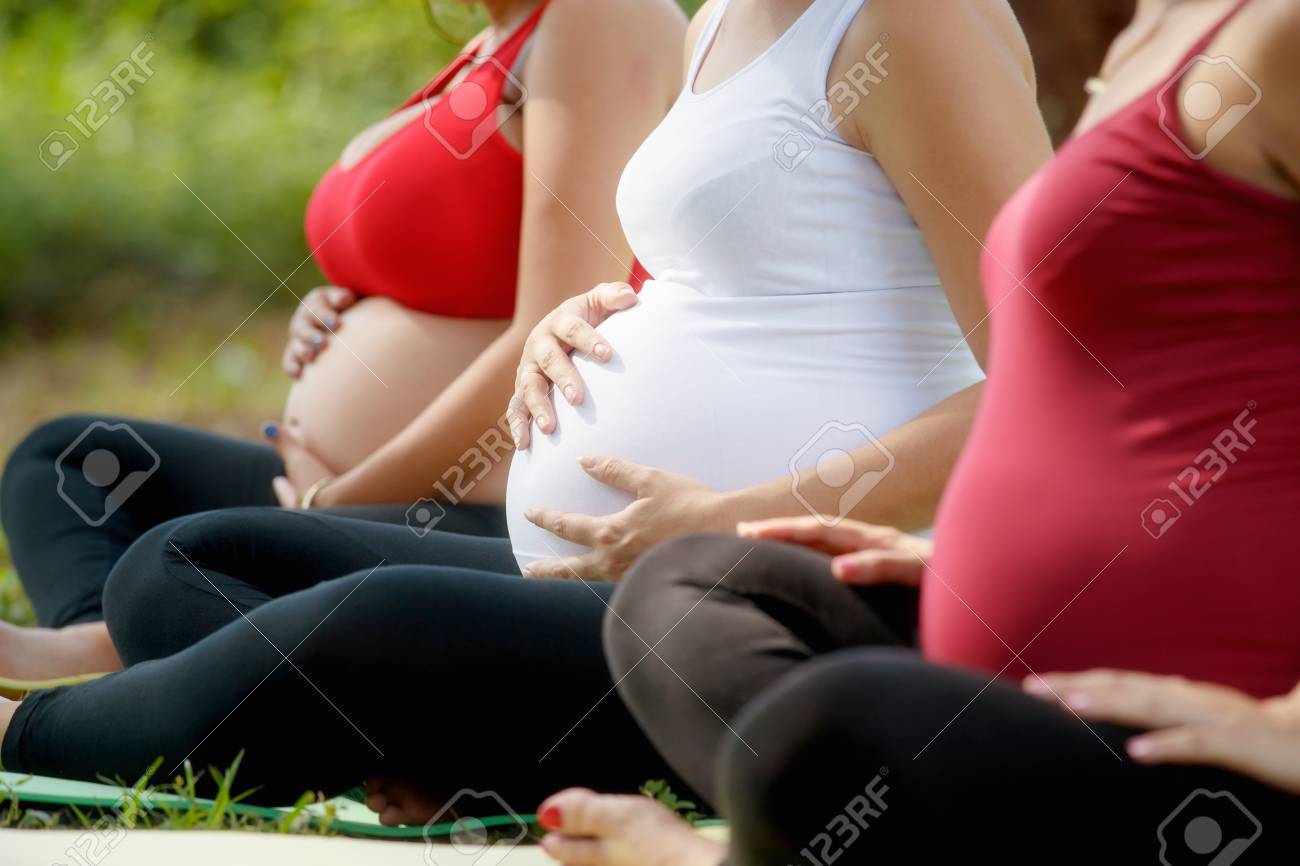 Pregnant women, group of moms during pregnancy attending prenatal lesson in city park. The girls massage their belly. - 82793874 Pregnant women, group of moms during pregnancy attending prenatal lesson in city park. The girls massage their belly. - 82793874