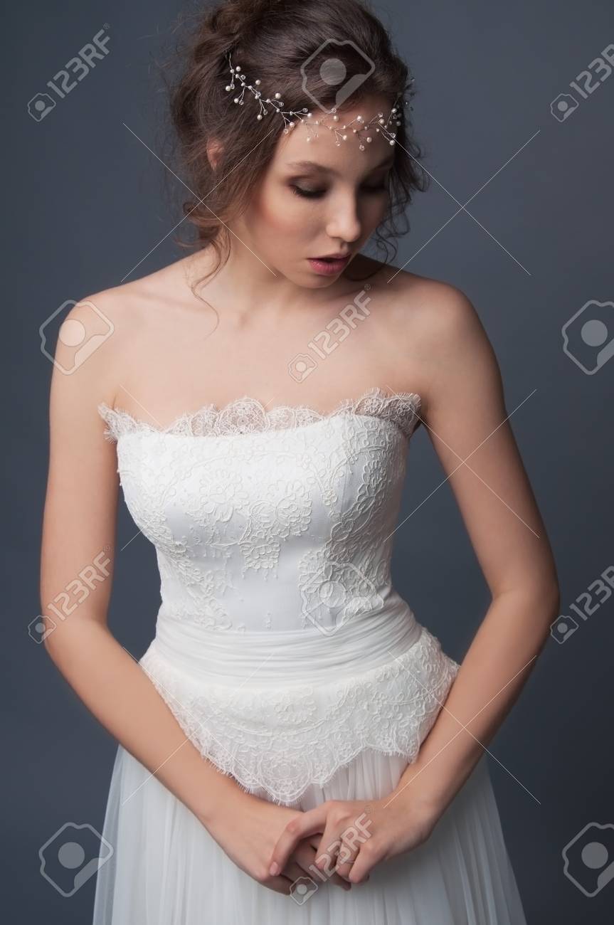 La Mode Nuptiale Coiffure Et Maquillage Brunette Mariée En Robe De Mariage Et Perles Têtière Sur Fond Gris
