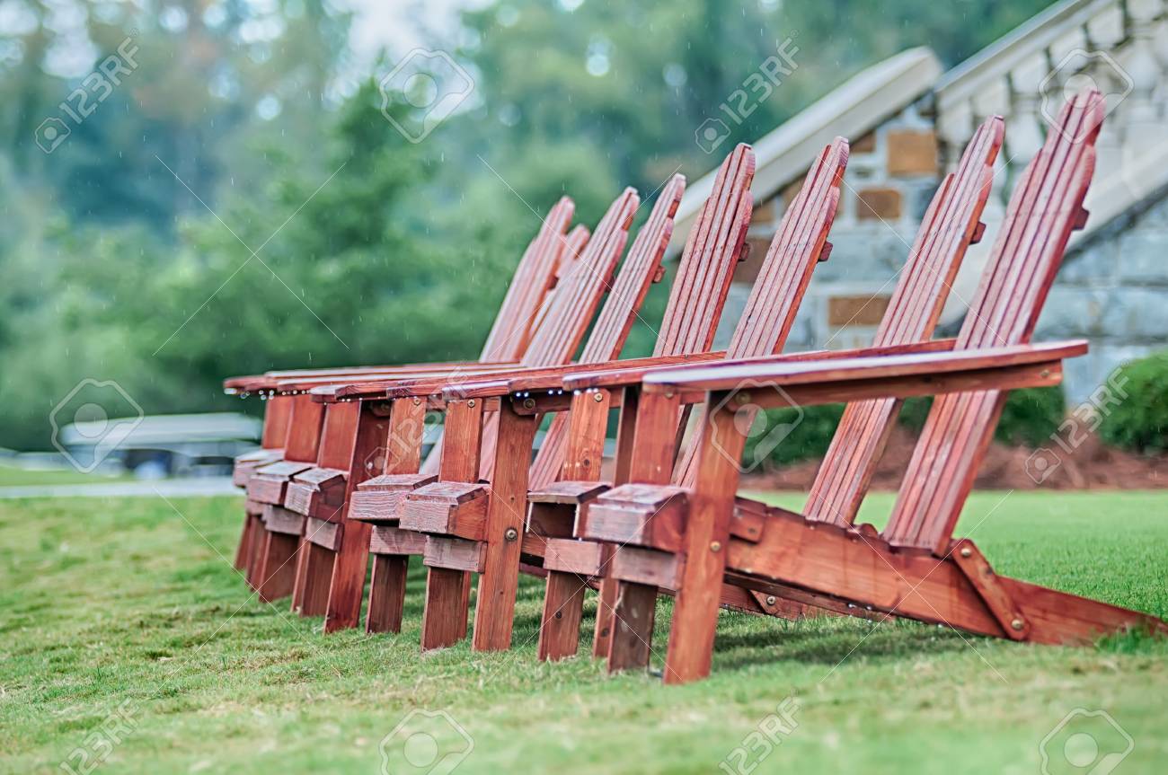 two wooden adirondack chairs on lush green lawn stock photo picture