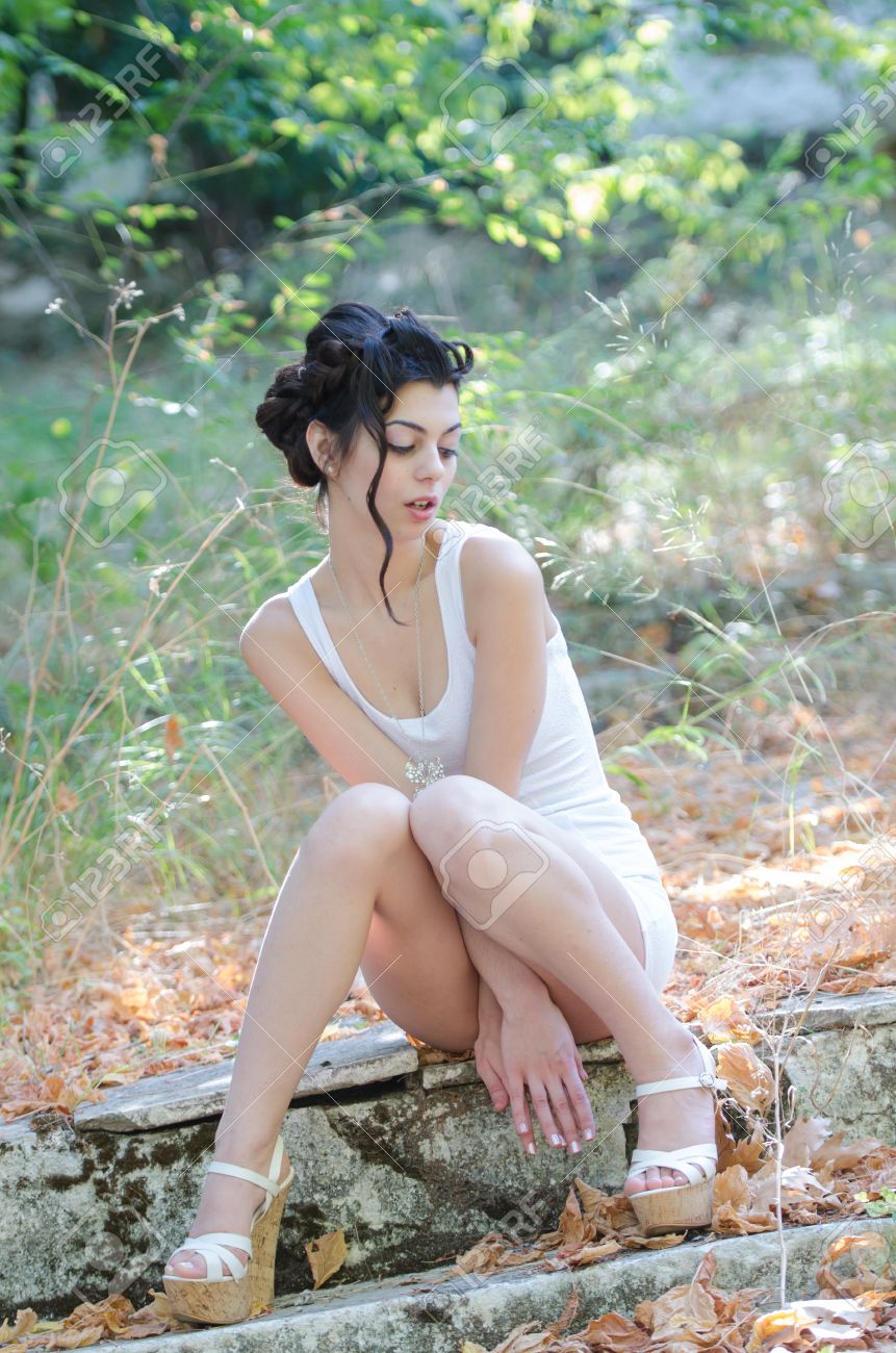 reizvolle dunne dame tragen enge kurzen weissen kleid auf dem burgersteig sitzen mit ihren beinen offen hat ihre hande zwischen den beinen platziert lizenzfreie fotos bilder und stock fotografie image 66376161