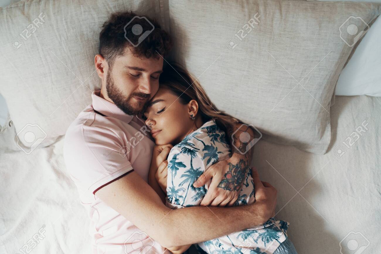 Couple In Love Is Embracing On The Bed. Man Hugging And Kissing ...