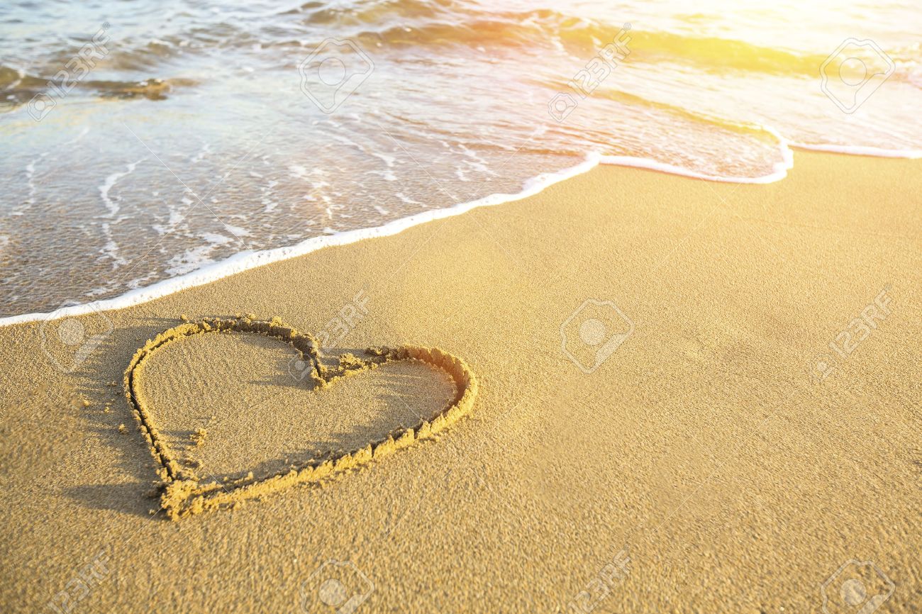 Heart drawn on the sand of a sea beach, soft wave and solar glare. - 39345304 Heart drawn on the sand of a sea beach, soft wave and solar glare. - 39345304