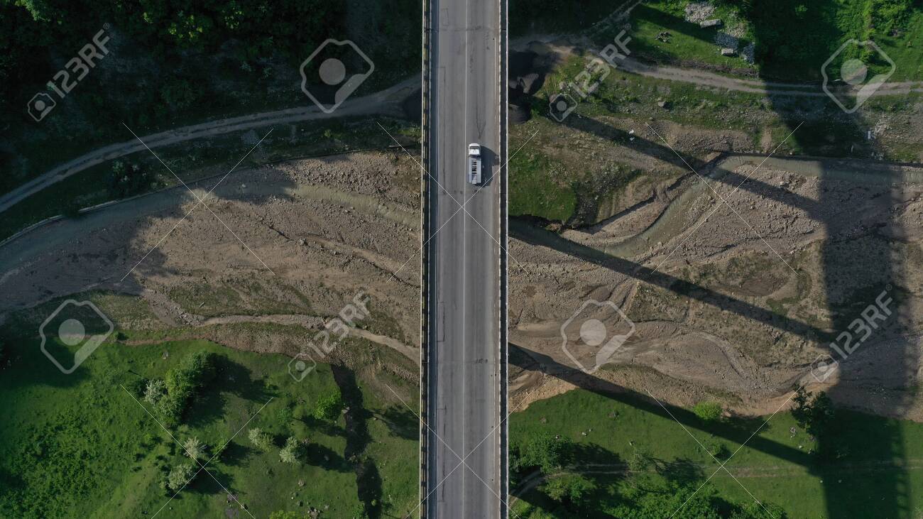 Aerial top down view of bridge over Aragvi river near Ananuri Fortress and Church. Mountain landscape. Summer. Green trees. Cars going on bridge road. Georgia. - 138810957 Aerial top down view of bridge over Aragvi river near Ananuri Fortress and Church. Mountain landscape. Summer. Green trees. Cars going on bridge road. Georgia. - 138810957