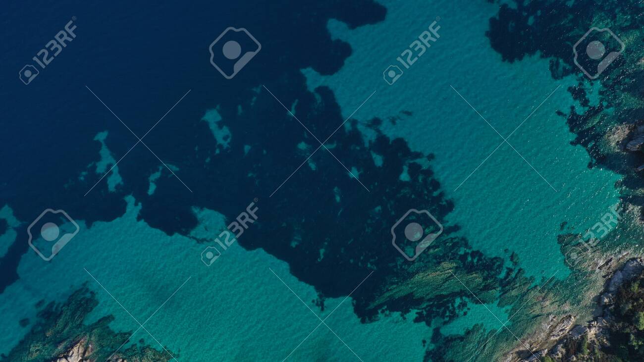 Aerial view of Halkidiki lagoon, Vouvourou beach, turquoise water of Aegean sea, rocks underwater. Greece seascape. - 140592818 Aerial view of Halkidiki lagoon, Vouvourou beach, turquoise water of Aegean sea, rocks underwater. Greece seascape. - 140592818