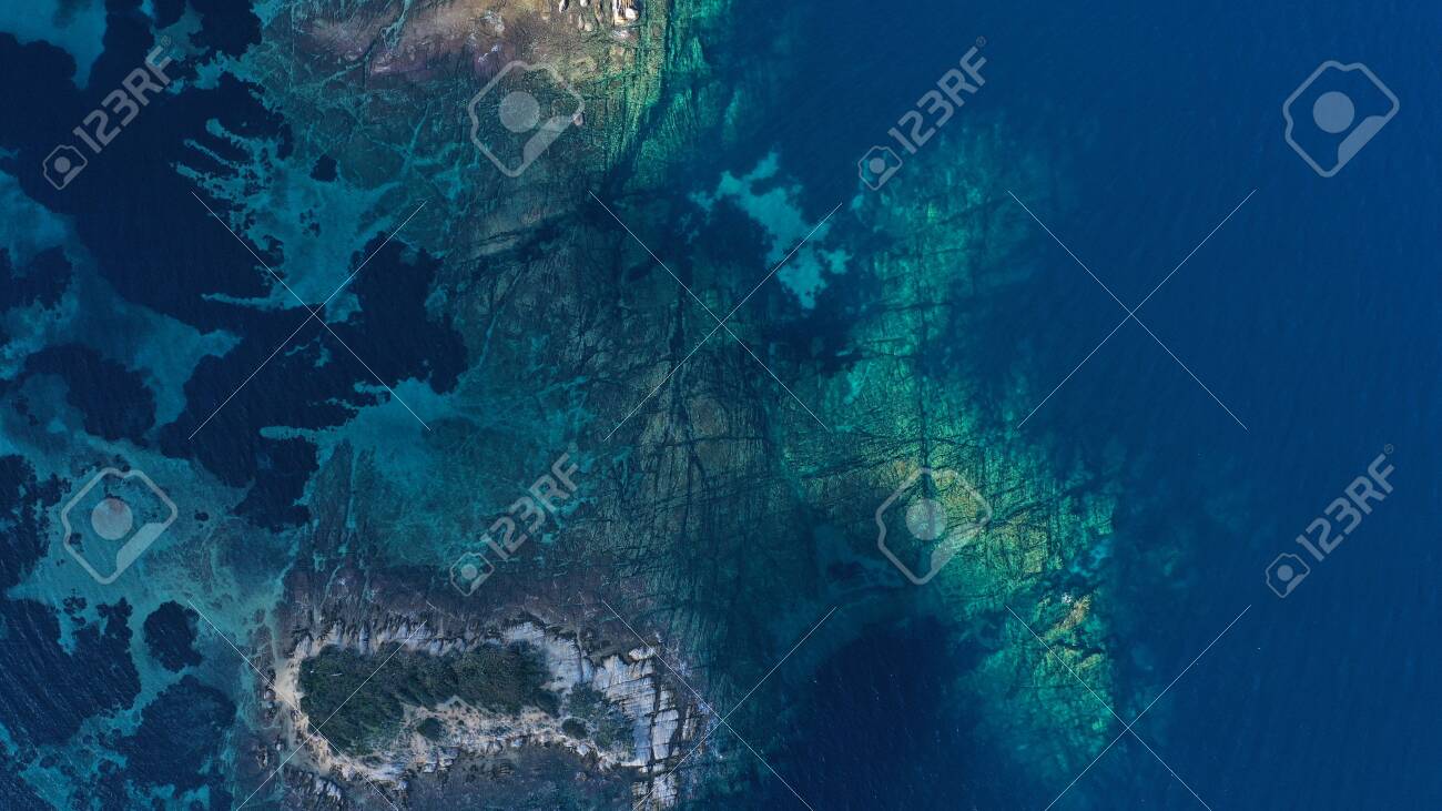 Aerial view of Aegean sea, turquoise water surface, Vourvourou beach, Kavourotripes beach, Sithonia peninsula, Halkidiki, Greece. Rocks, stones underwater. - 140592869 Aerial view of Aegean sea, turquoise water surface, Vourvourou beach, Kavourotripes beach, Sithonia peninsula, Halkidiki, Greece. Rocks, stones underwater. - 140592869