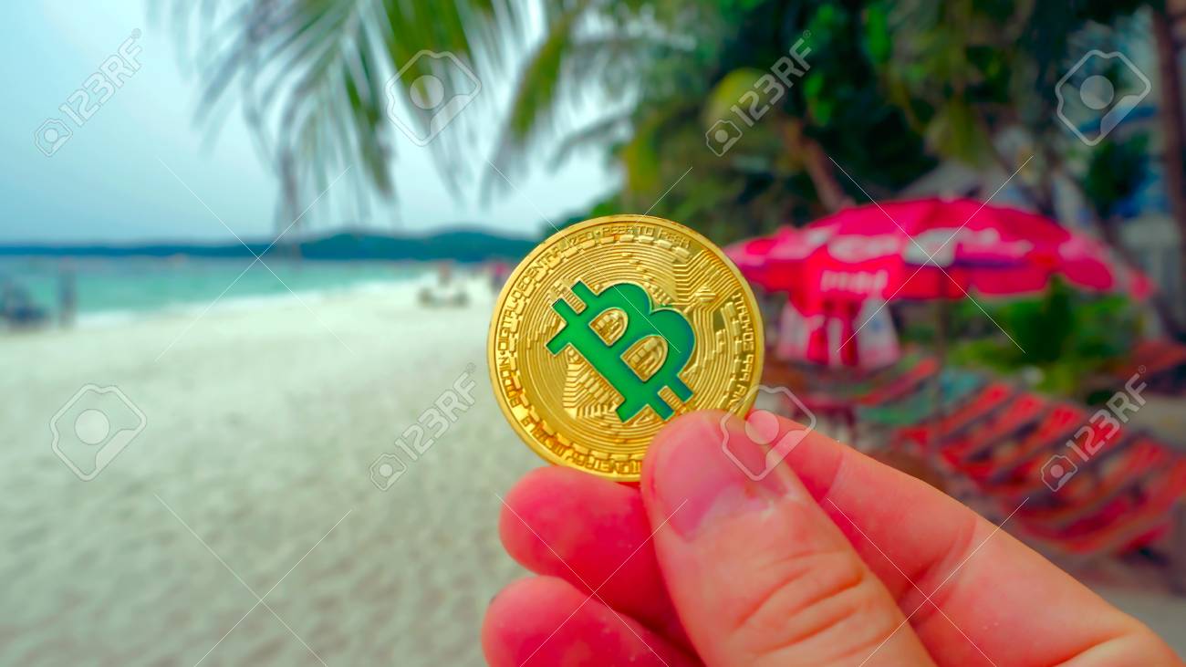 Hand Holding Golden Bitcoin On The Beach, On The Background Of Sea Wave.  Bitcoin Is A Modern Way Of Exchange This Crypto Currency Is A Convenient  Means Of Payment In The Financial.