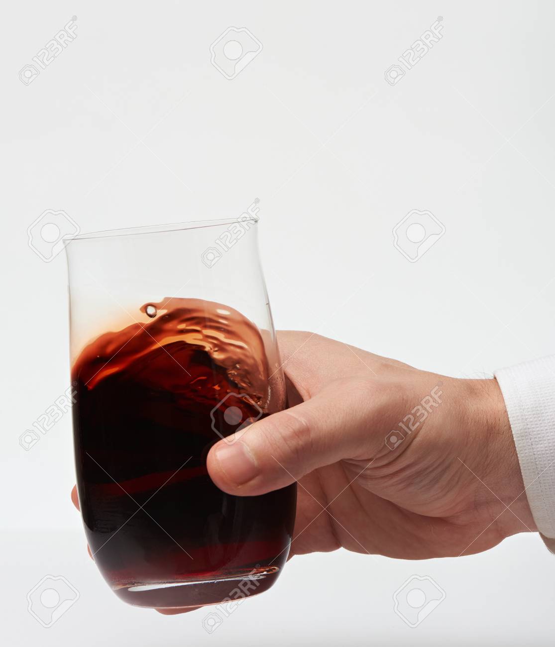 Red Wine In Stemless Glass In Hand Isolated On White Background