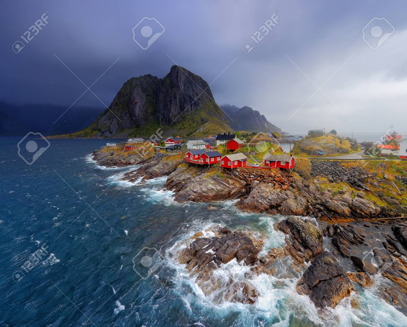 ノルウェー漁村ロフォーテン諸島のレーヌ 石の海岸線に赤いノルウェーがり家 荒天で北欧の自然 ノルウェーの漁村の近く青い海の波 の写真素材 画像素材 Image