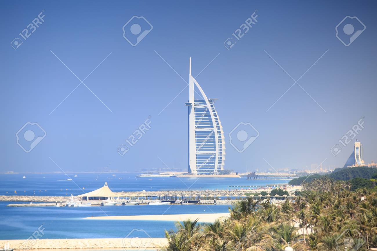 Luxury seven stars hotel in Dubai. Burj Al Arab Jumeirah resort hotel on blue sky background. Sunny Dubai resort. - 89511906 Luxury seven stars hotel in Dubai. Burj Al Arab Jumeirah resort hotel on blue sky background. Sunny Dubai resort. - 89511906