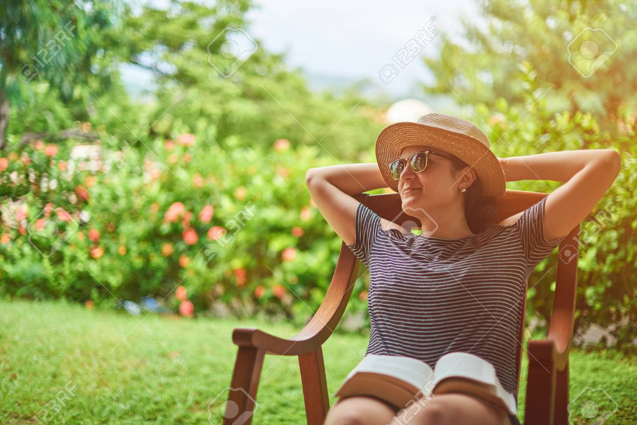 Summer vacation concept. Young woman sitting in backyard - 91180178 Summer vacation concept. Young woman sitting in backyard - 91180178
