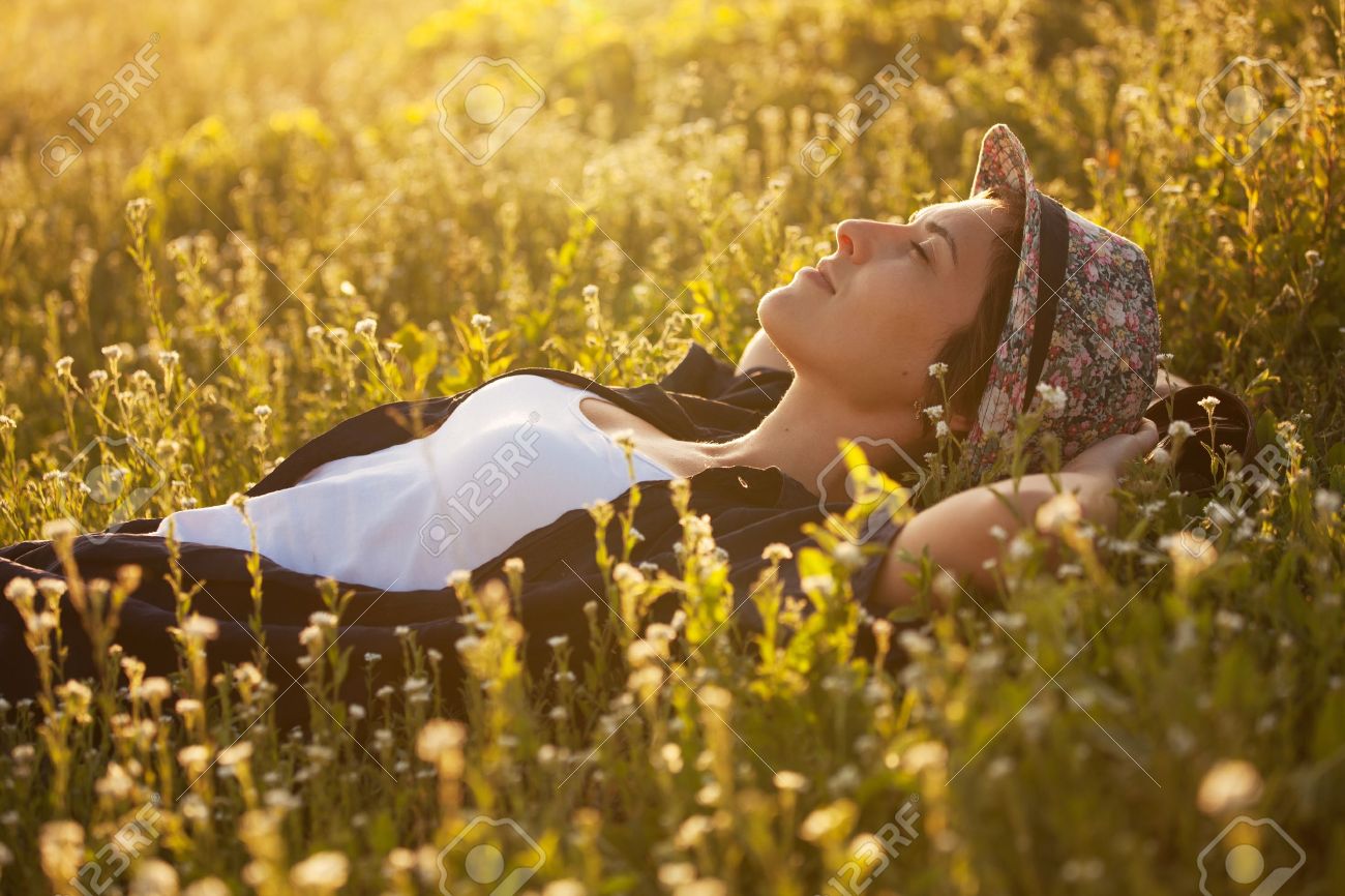 The girl in a hat dremet among wildflowers at sunset - 20593862 The girl in a hat dremet among wildflowers at sunset - 20593862