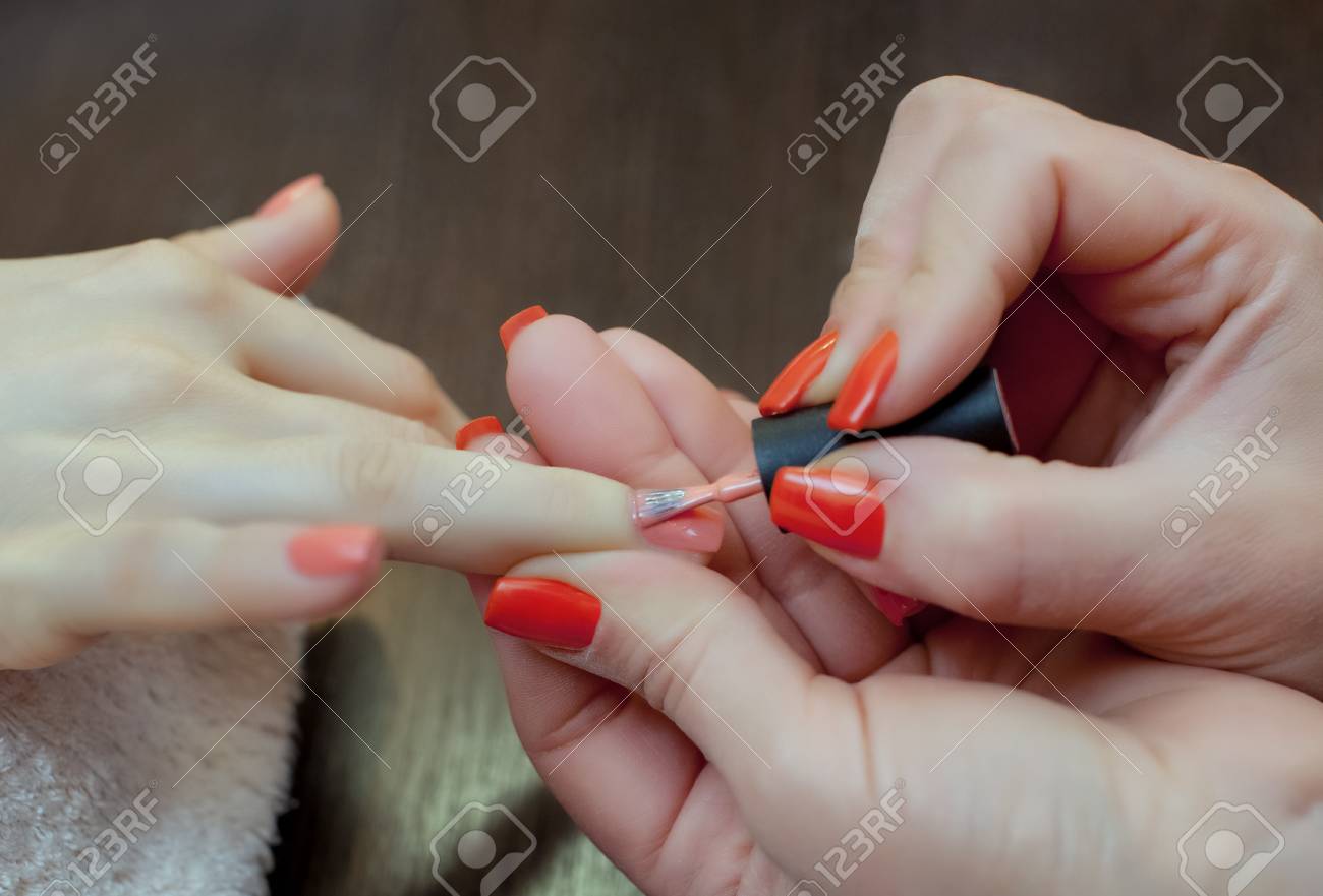 nail technician paints nails with nail polish during the procedure nails technician