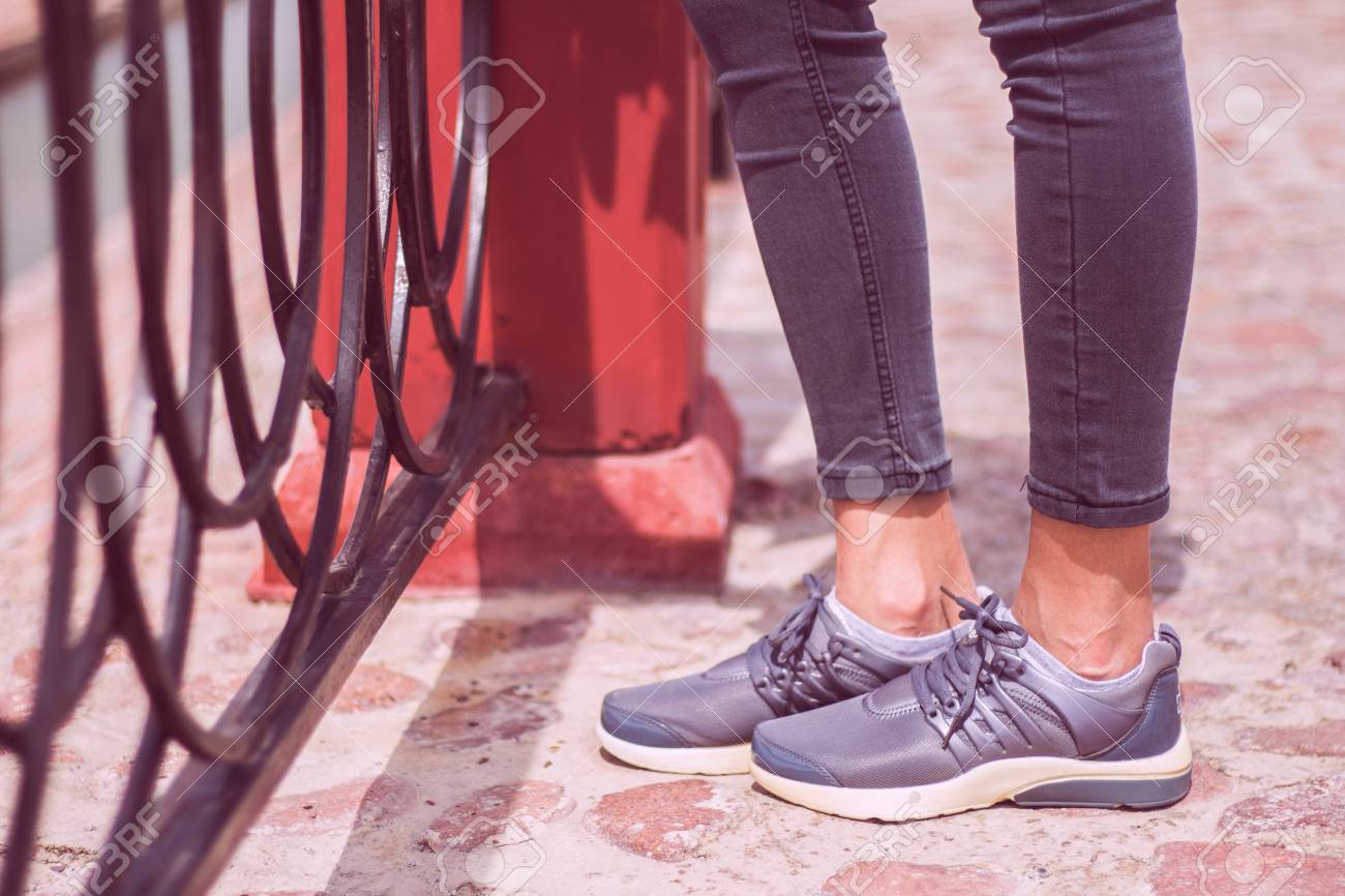 Carretera Y Los Zapatos Jóvenes Zapatillas Deportivas Las En Vaqueros Cerca De Pantalones Caminando La VallaOcio Pie Metal Chicas Estilo rshQCtdx