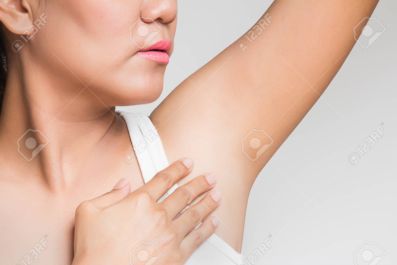 女性は彼女の腕を持ち上げて脇の下を見せて の写真素材 画像素材 Image