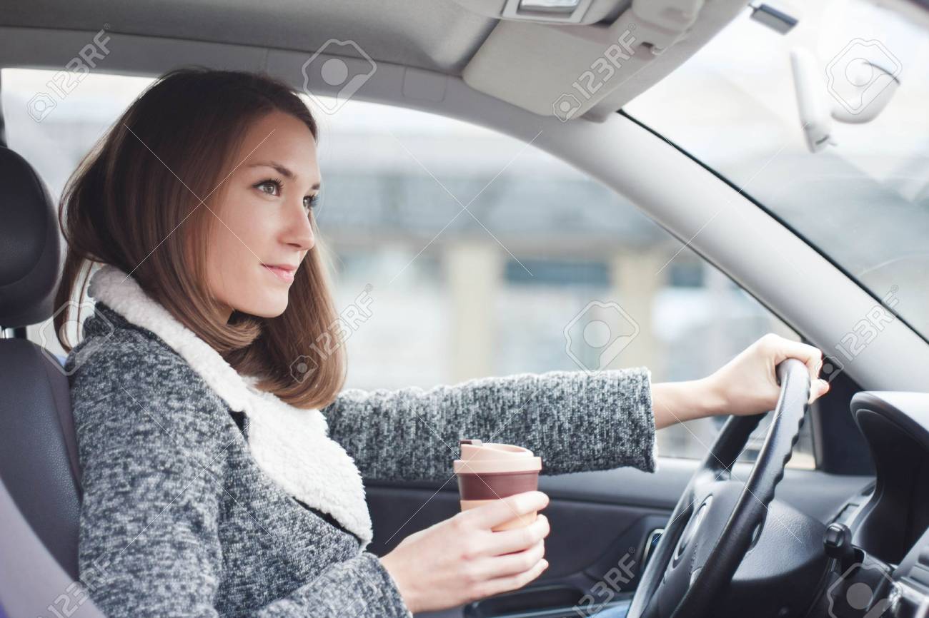 若い女性がコーヒーを持って町で車を運転 の写真素材 画像素材 Image 若い女性がコーヒーを持って町で車を運転 の写真素材 画像素材 Image