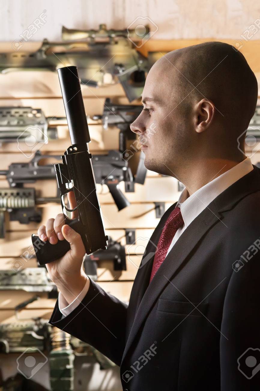 武器庫壁背景に銃を持つ禿げたヒットマン の写真素材 画像素材 Image
